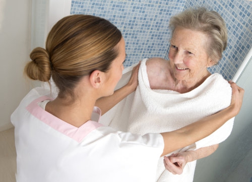 elderly woman taking a bath with her caretaker